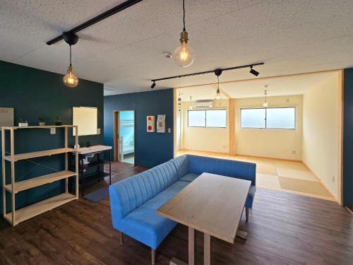 un soggiorno con un divano blu e un tavolo di Petit villa Sea grapes a Nago