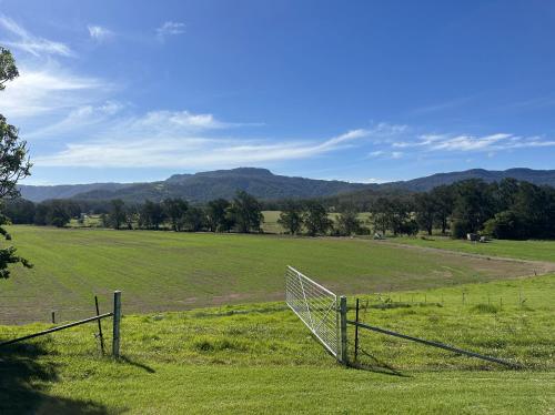 a fence in a field with mountains in the background at Hillview Studio One in Berry