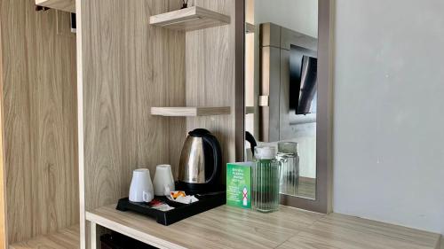 Una encimera de cocina con una cafetera y un espejo. en The Baliem Hotel, en Jimbaran