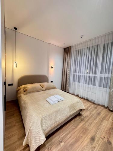 a bedroom with a large bed and a large window at Аппартамент в Астане in Astana