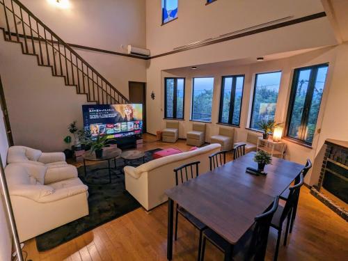 uma sala de estar com um sofá e uma mesa em SAKURA Cottage Izukogen em Ito