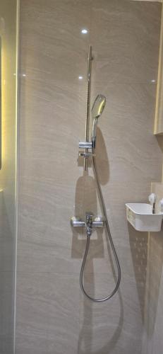 a shower in a bathroom with a sink at Nakula at Waterplace Residence in Surabaya