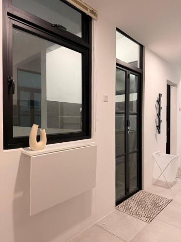 a room with a window with a vase on a shelf at StayCO - D'Millenia Residences - Studio Unit in Kuching
