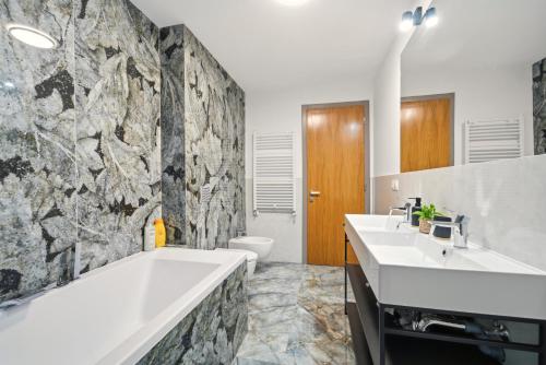 a bathroom with two sinks and a bath tub at Central Accommodation in Monarh Tower by Open House apartments in Timişoara