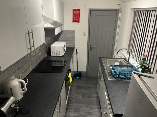 a kitchen with a sink and a counter top at Shelton Guest House in Stoke on Trent