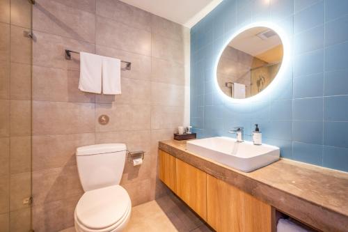 a bathroom with a toilet and a sink and a mirror at Home Inn Yuncheng Yuxi Road Yudu in Yuncheng