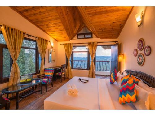 a living room with a couch and a balcony at goSTOPS Mukteshwar in Mukteswar
