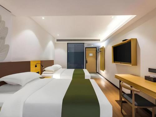 大同市にあるGreenTree Inn Express Datong High-Speed Railway Station Old City Wallのベッド2台、机、テレビのある寝室