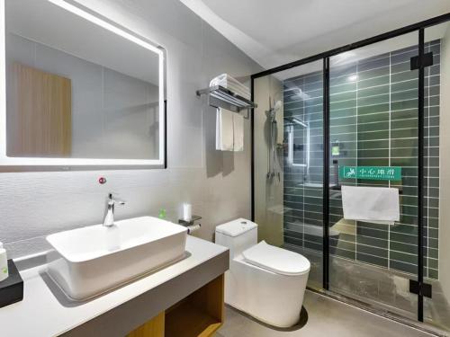 a bathroom with a sink and a toilet and a shower at GreenTree Inn Express Datong High-Speed Railway Station Old City Wall in Datong