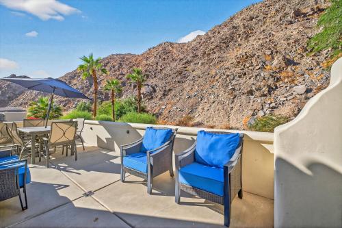 a patio with chairs and tables and a mountain at LV305 Legacy Villas Townhome w Expansive Patio in La Quinta