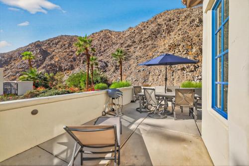 a patio with chairs and tables and an umbrella at LV305 Legacy Villas Townhome w Expansive Patio in La Quinta