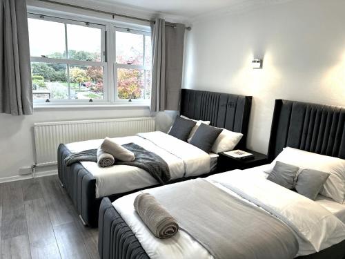 une chambre d'hôtel avec deux lits et une fenêtre dans l'établissement Ama comfort Stay, à Hythe