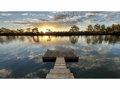 a wooden dock in the middle of a lake at River Murray Views in Nildottie