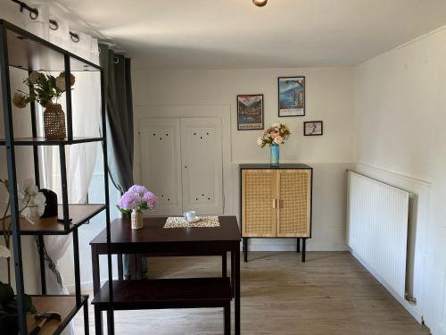 ein Wohnzimmer mit einem Tisch und Blumen an der Wand in der Unterkunft Appartement au cœur de la Riviera in Montreux