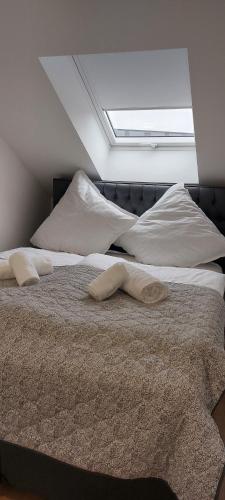 a bedroom with two white beds with a skylight at City Appartement in Mönchengladbach