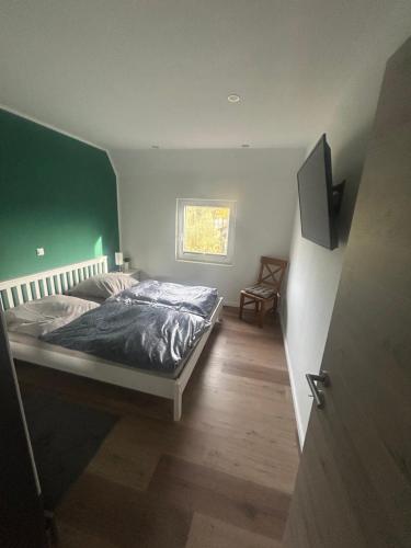 a bedroom with a bed and a green wall at Ferienwohnung Weber in Bergen