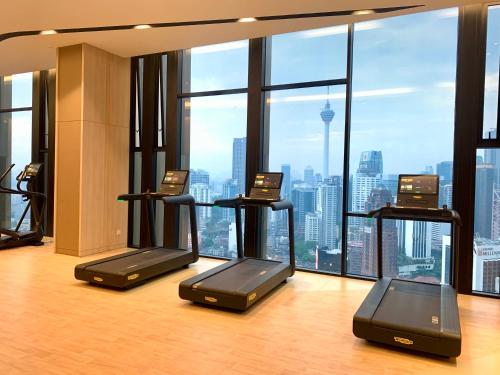 ein Fitnessstudio mit Laufbändern vor einem großen Fenster in der Unterkunft Axon Residence by Perkasa Ikon Homestay in Kuala Lumpur