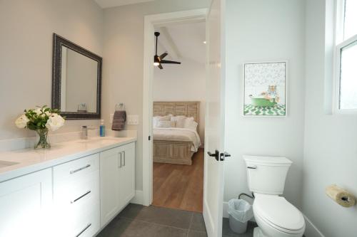 a bathroom with a toilet and a bedroom with a bed at Destination #45 in Orange