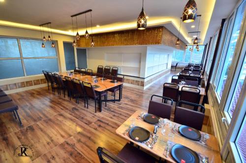a dining room with wooden tables and chairs at Royal Serene Villas in Ooty