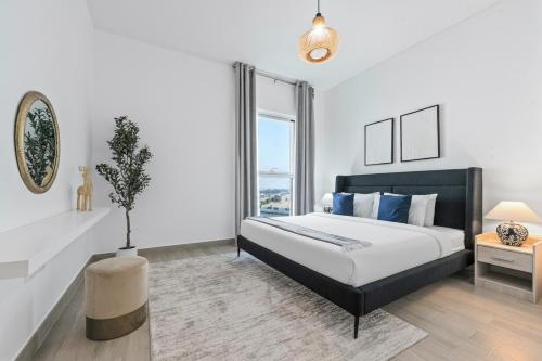 a white bedroom with a bed and a window at Yas Island 2BR Luxury Apartment by Ferrari World in Abu Dhabi