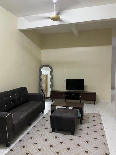 a living room with a couch and a piano at Dua Puteri Homestay 