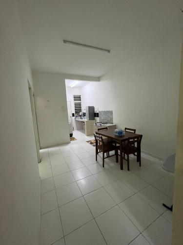 a room with a table and chairs and a kitchen at Dua Puteri Homestay 
