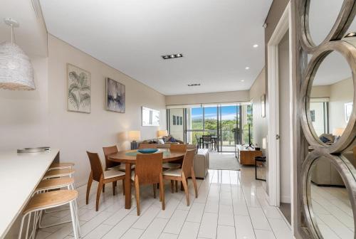a dining room and living room with a table and chairs at Bali Luxury Resort - Holiday Management in Kingscliff