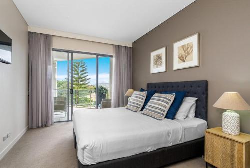 a bedroom with a large bed and a balcony at Bali Luxury Resort - Holiday Management in Kingscliff