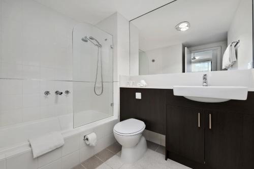 a bathroom with a toilet and a sink and a shower at Quest Dandenong in Dandenong