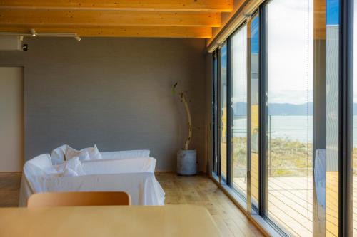 een kamer met 2 tafels en een groot raam bij Yunagi 夕凪 