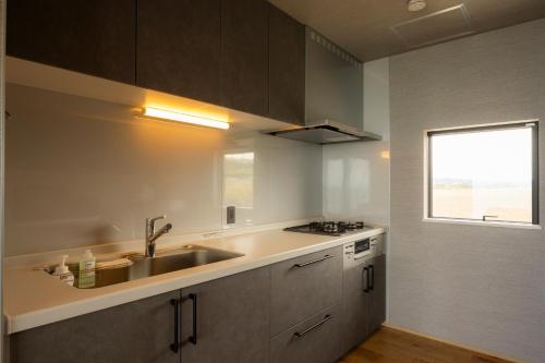 een grote keuken met een spoelbak en een raam bij Yunagi 夕凪 