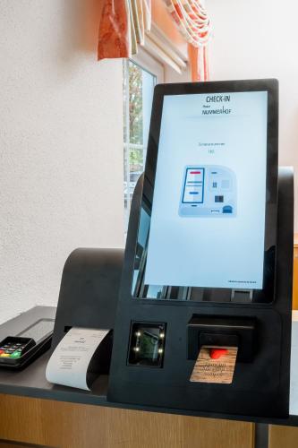 a cash register on a desk with a cell phone at Mikro Apartments Erding in Erding