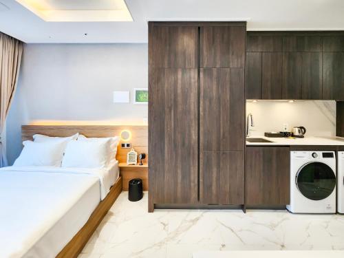 a bedroom with a bed and a washing machine at Paramion Hotel in Busan