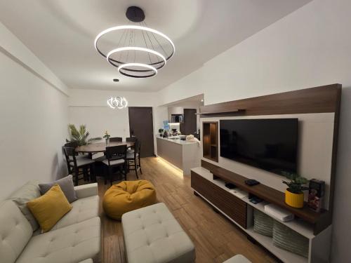 un soggiorno con un divano e una televisione di Penthouse entre nubes y volcanes a Quetzaltenango