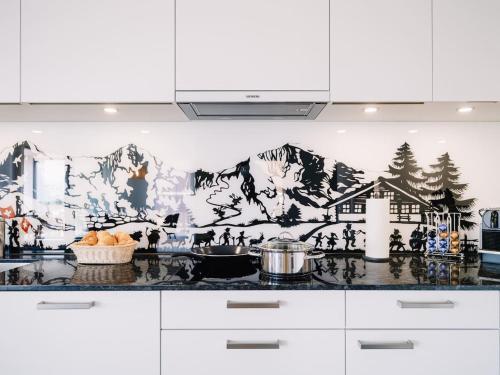 eine Küche mit einem Wandbild an der Wand in der Unterkunft Apartment Stockhorn in See- und Bergnähe, modern, mit Balkon, 4 Gäste in Einigen