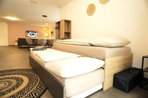 una camera con tre letti e un soggiorno di Apartment Niesen Lake Stay a Einigen