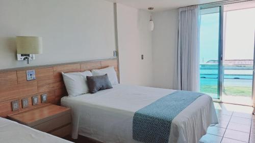 a bedroom with a bed with a view of the ocean at Hotel Playamar in Mazatlán