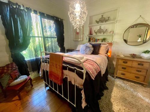 une chambre avec un lit, une commode et une fenêtre dans l'établissement PET Friendly Miners Cottage 'Baraka BnB', à Kalorama