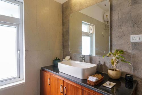 un bagno con lavandino e specchio di amã Stays & Trails Isley, Dhauj Haryana a Dhauj