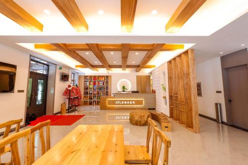 ein Wohnzimmer mit Tisch und Kamin in der Unterkunft Xuegu Xuefu Lai Inn in Wuchang