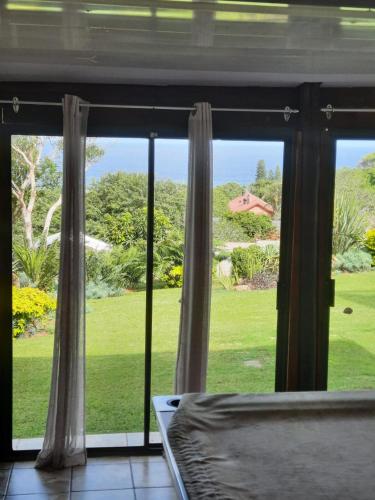 a bedroom window with a view of a yard at Sea shells self catering in Hibberdene
