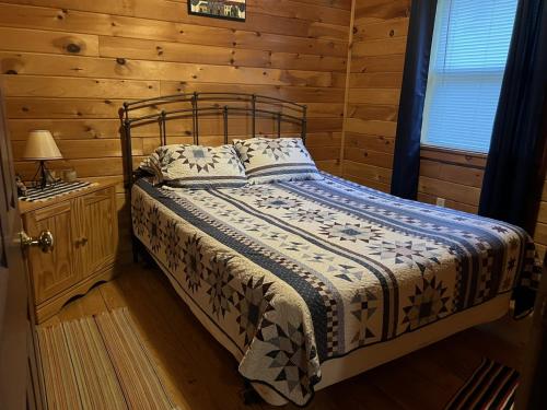 ein Schlafzimmer mit einem Bett in einer Blockhütte in der Unterkunft Bitter Goose Cabin in Barnettstown