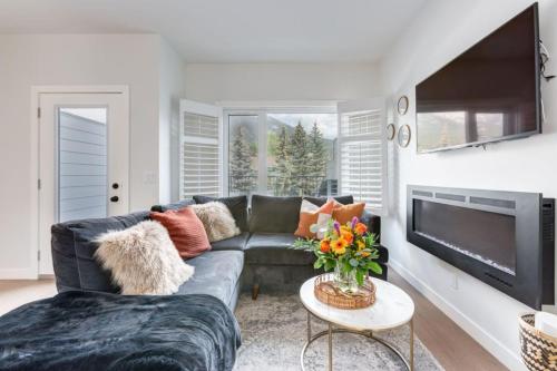 a living room with a couch and a tv at Stunning Modern 2BR Unit in Downtown Canmore in Canmore
