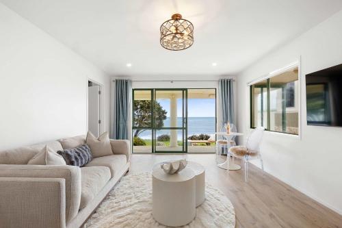 a living room with a couch and a table at Wanaka Studio - sea views from your private patio in New Plymouth