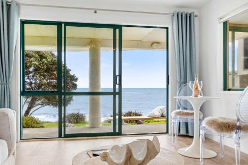 a living room with a view of the ocean at Wanaka Studio - sea views from your private patio in New Plymouth