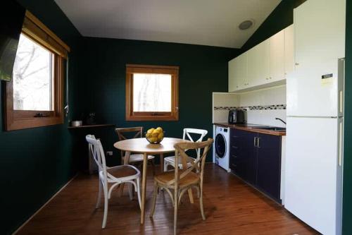 a kitchen with a table and chairs in a room at Central studio with spabath in Daylesford