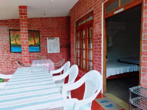 a patio with a table and chairs and a bed at Ella Tea Land View in Ella