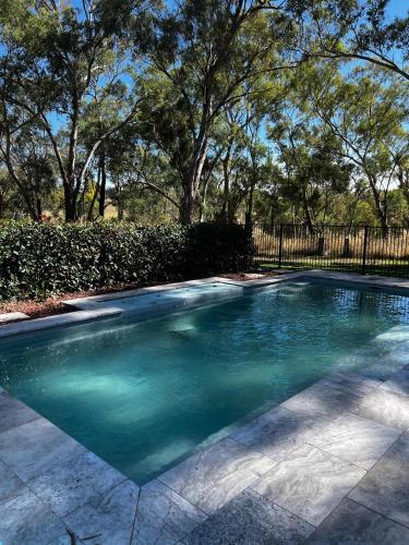 a swimming pool with blue water in a yard at Fallenwood - Vineyard Escape in Orange