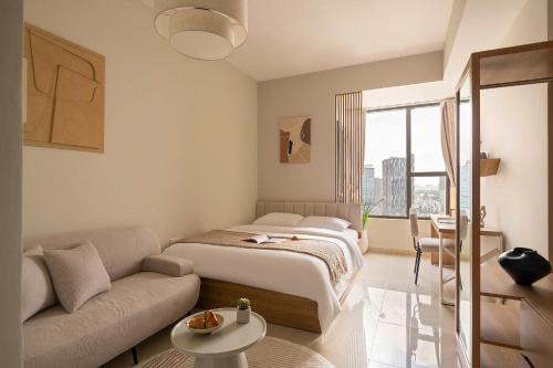 ein Schlafzimmer mit einem großen Bett und einer Couch in der Unterkunft Rivergate Residence by Maison de Gu - Premium Studios, 2BRs, 3BRs Living in District 4, Steps from District 1, 300M BUI VIEN in Ho-Chi-Minh-Stadt