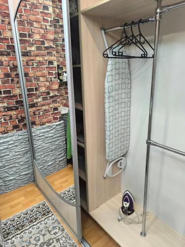 a walk in shower in a room with a brick wall at Апартаменты на Бараева in Astana